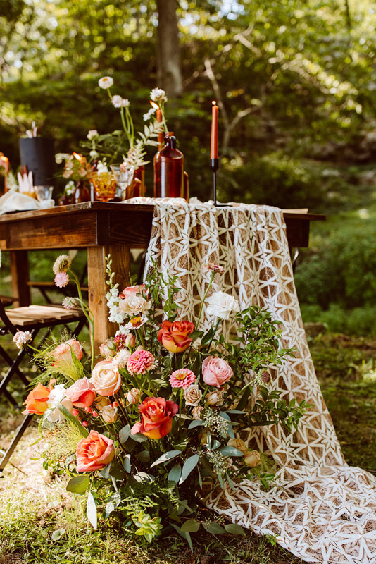 Floral arrangement at foot of romantic tablescape