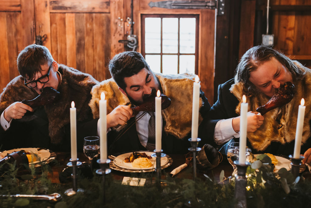 Three men eating turkey legs in their medieval attire