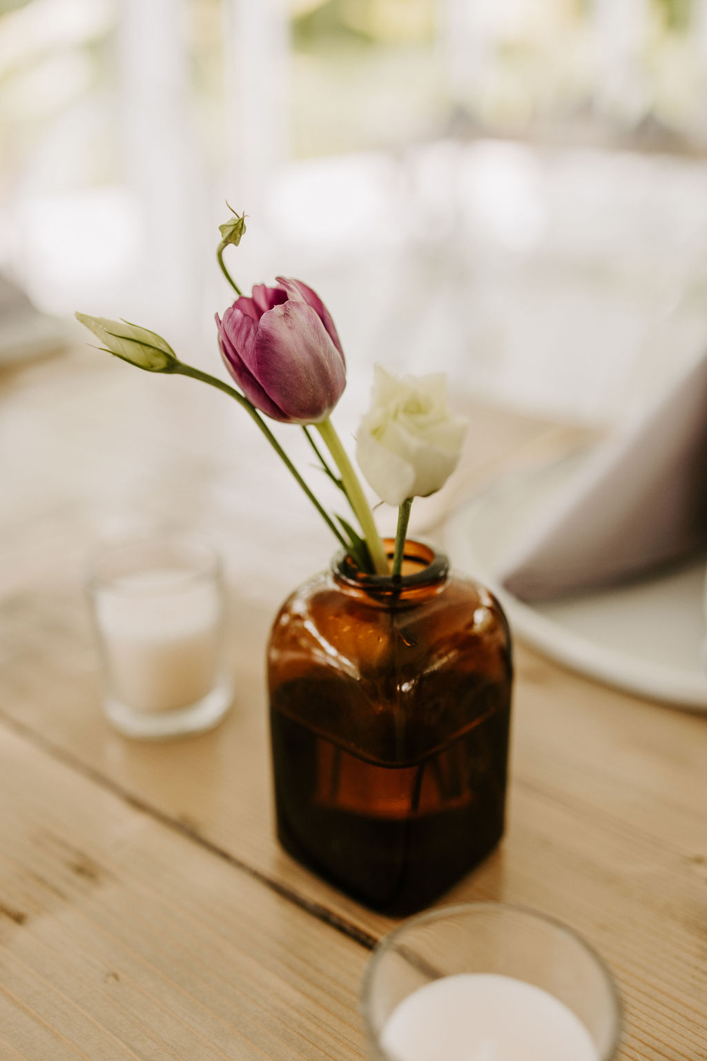 Amber bud vase with purple tulip