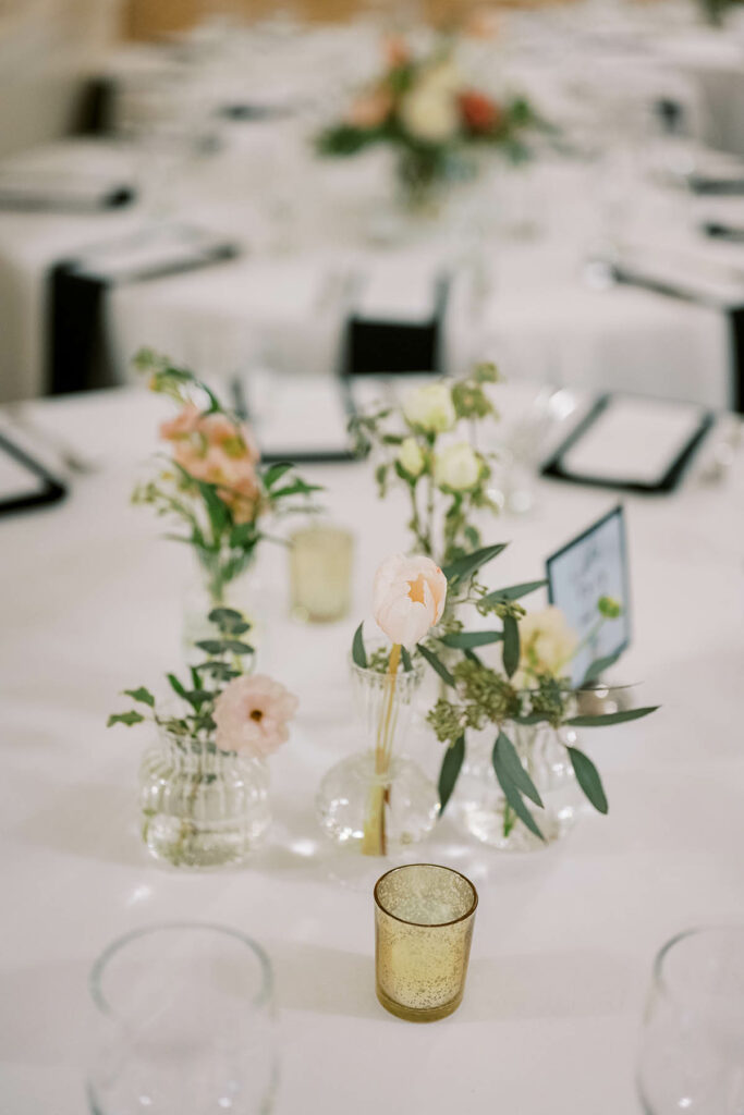 Bud vases on the table with muted pastel flowers