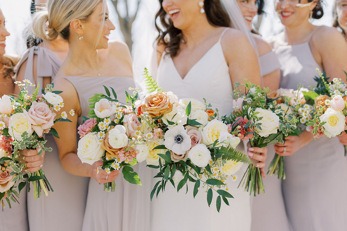 Close up of bouquets with anemone, roses, ranunculus, and chamomile