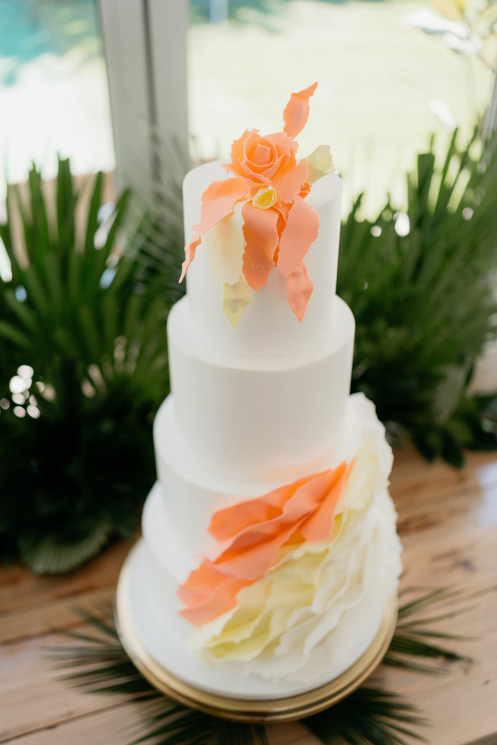 Tall white cake with orange and yellow ruffles