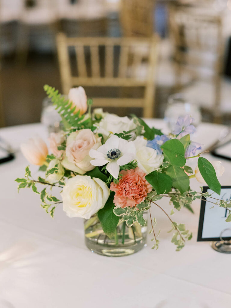 Low floral centerpiece with muted pastel flowers