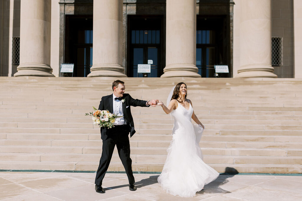 Bride and groom dancing at the foot of staircase