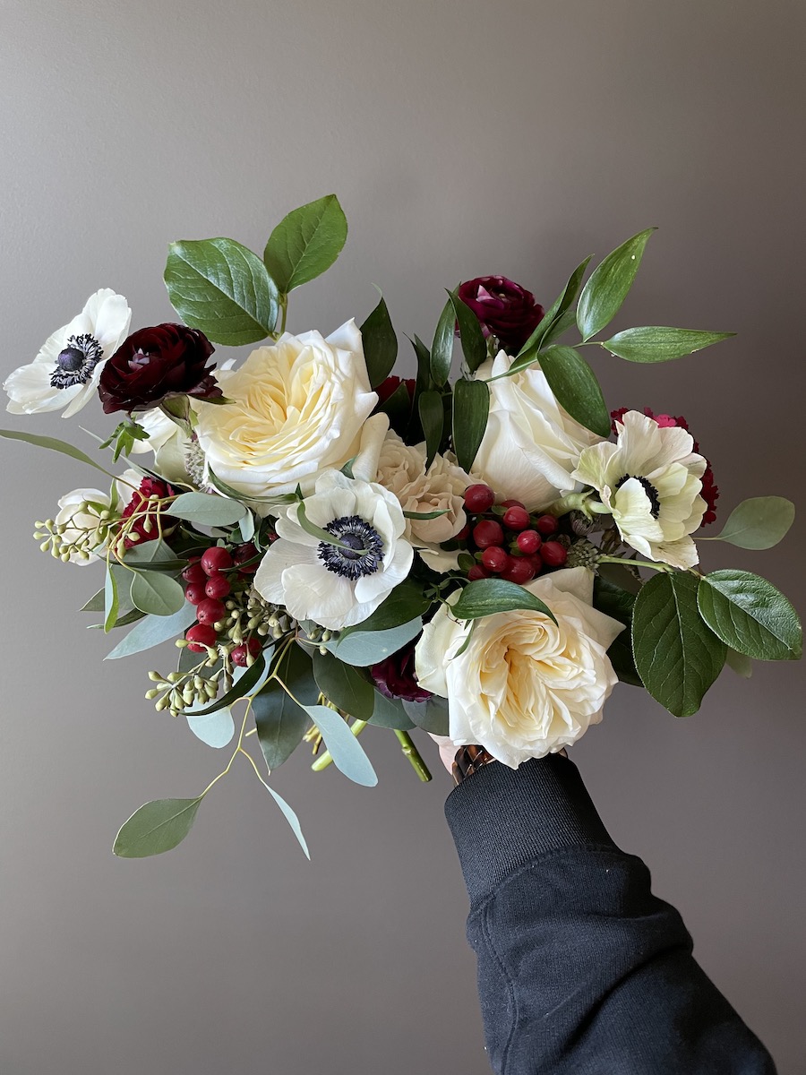Romantic bouquet with white garden roses and deep burgundy ranunculus