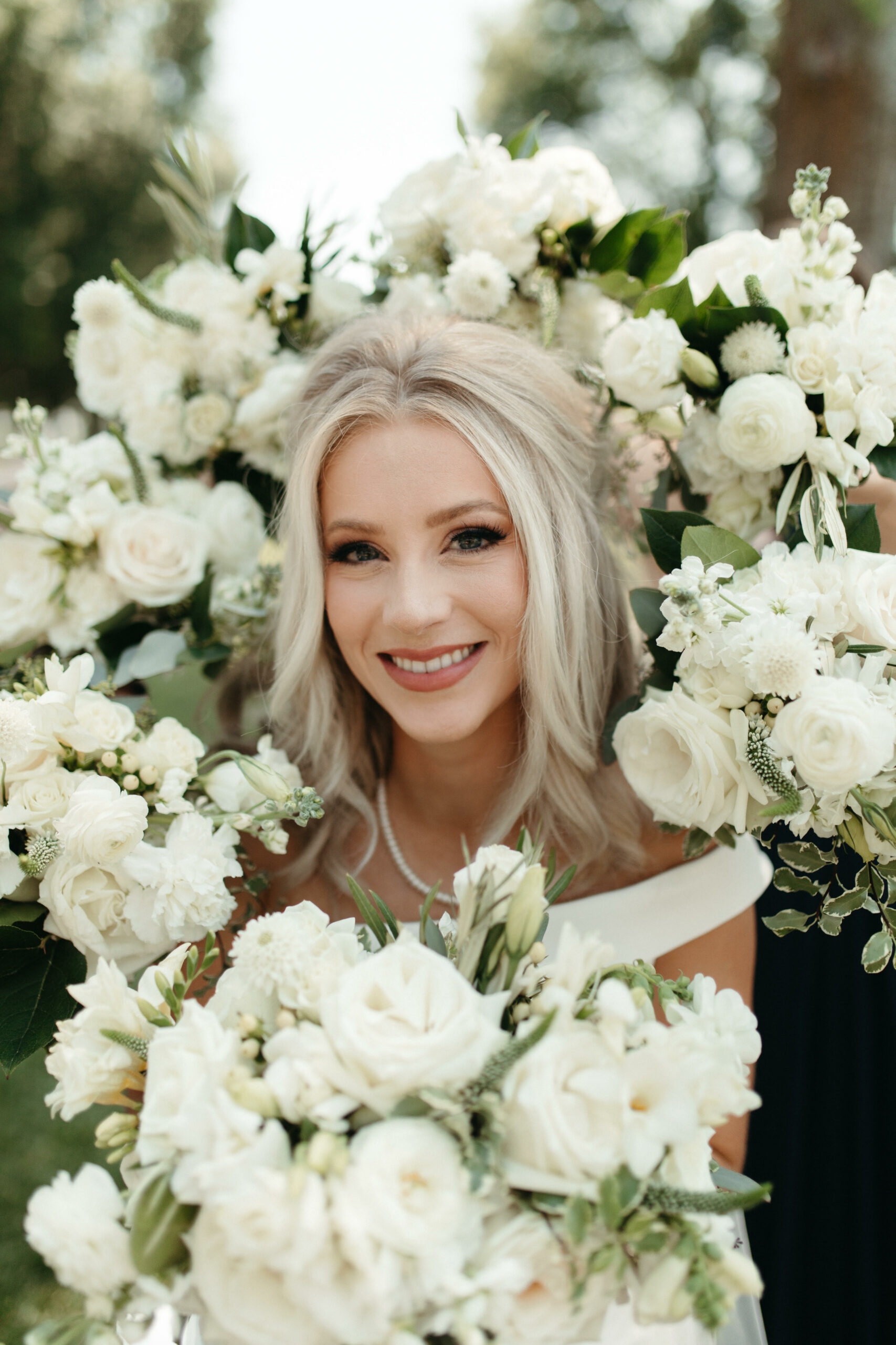 Fluffy white wedding bouquets encircling the bride's face