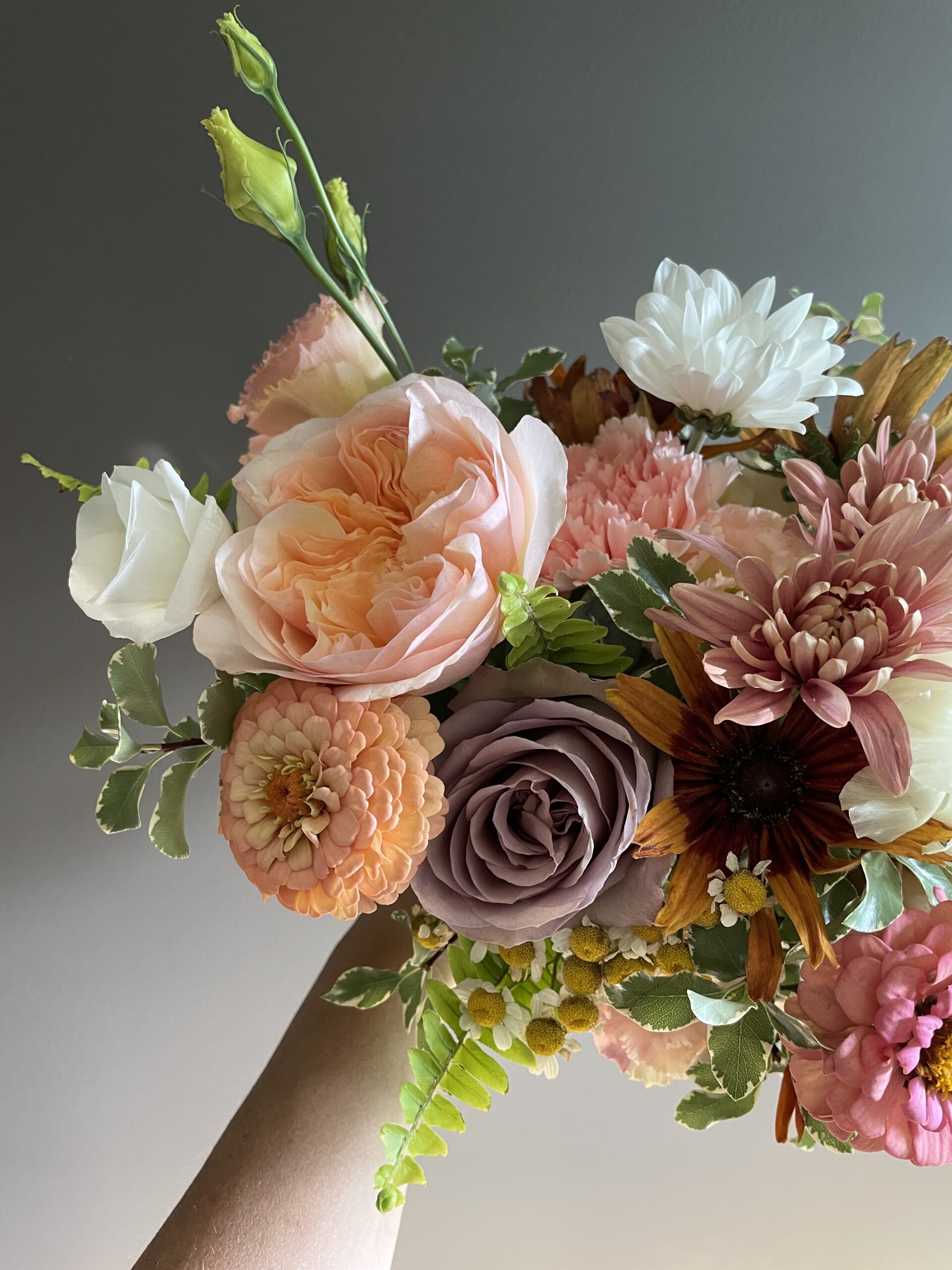 Peach, mauve, rust, and lavender flowers in bridal bouquet