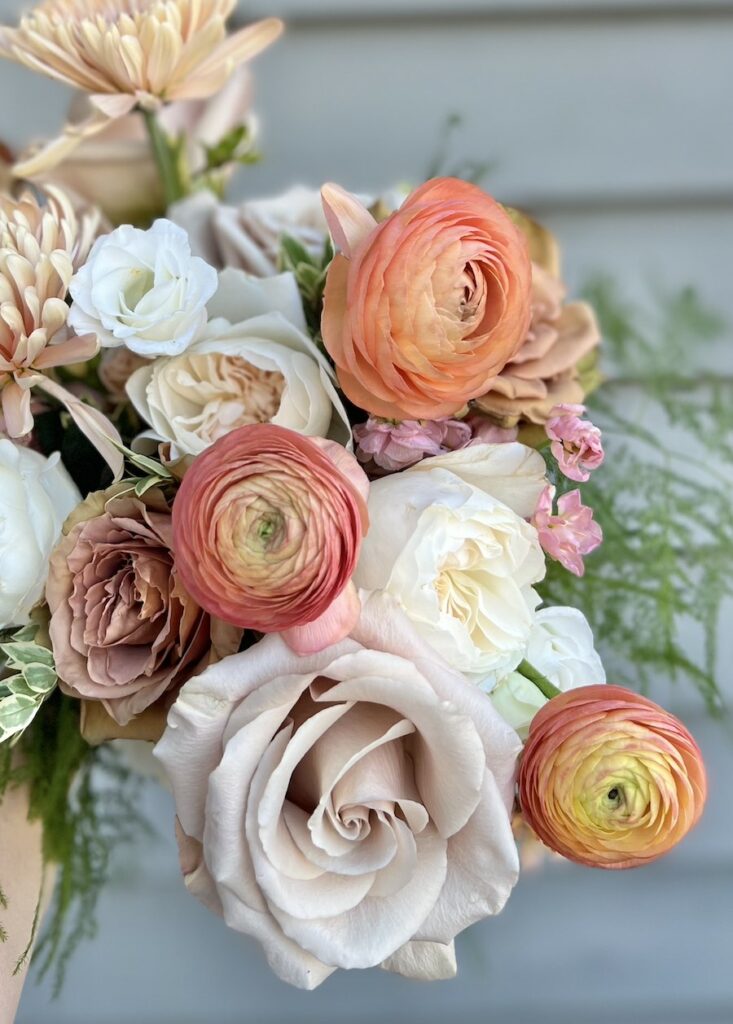 Close up of lush flowers in peach and salmon bouquet
