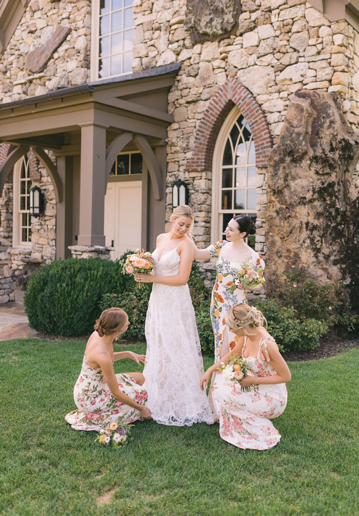 Bridesmaids doting on bride, holding their bouquets