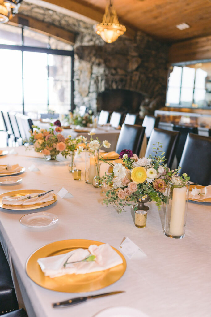 Two floral arrangements on rectangular guest table for a Big Cedar Wedding.