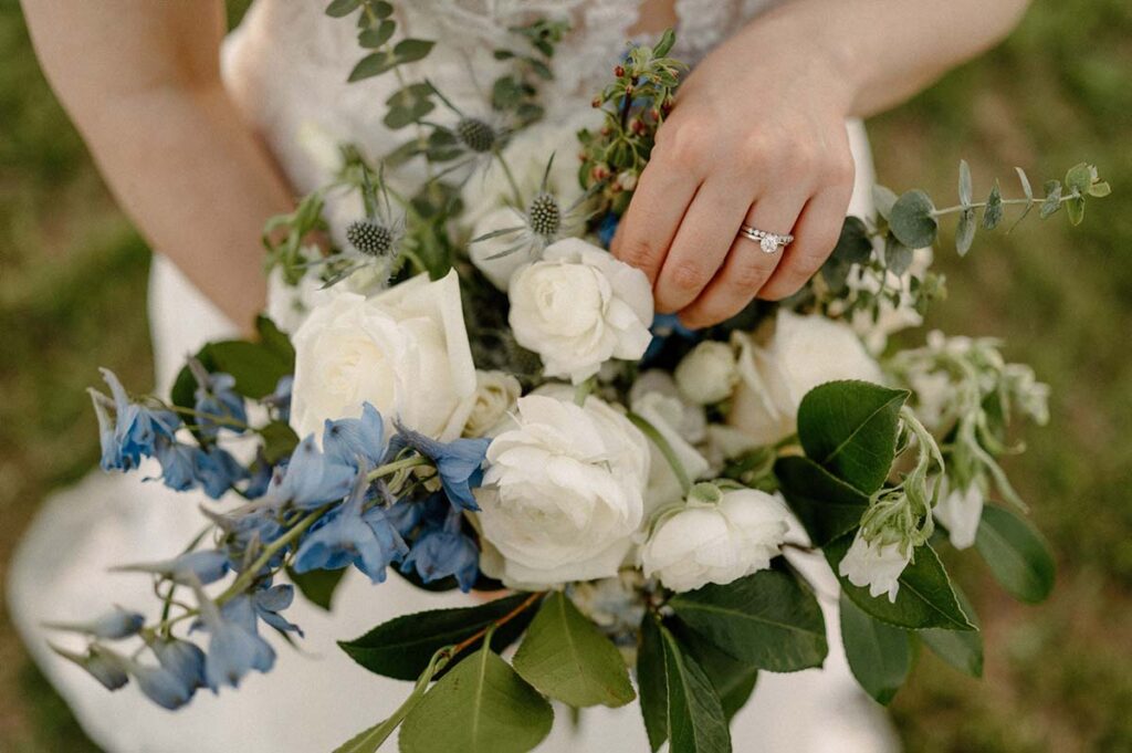 Close up of bride touching her bouquet