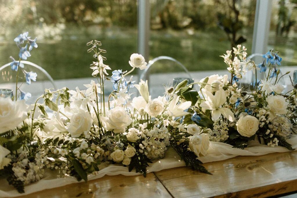 Detail shot with dramatic lighting shining through the petals of the white flowers in centerpiece