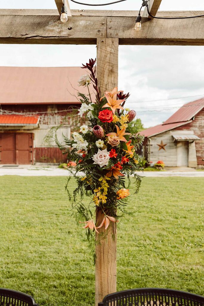 Statement floral piece attached to a pillar behind the reception table