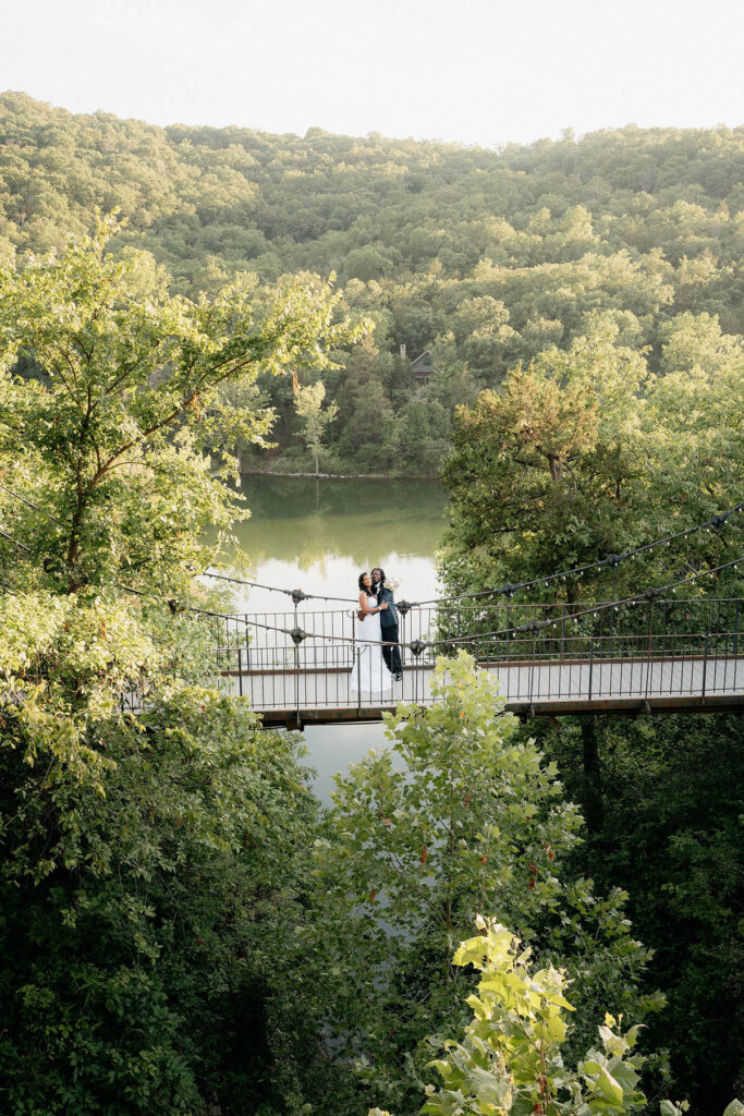 Newlywed portrait on a bridge with expansive landscape around them