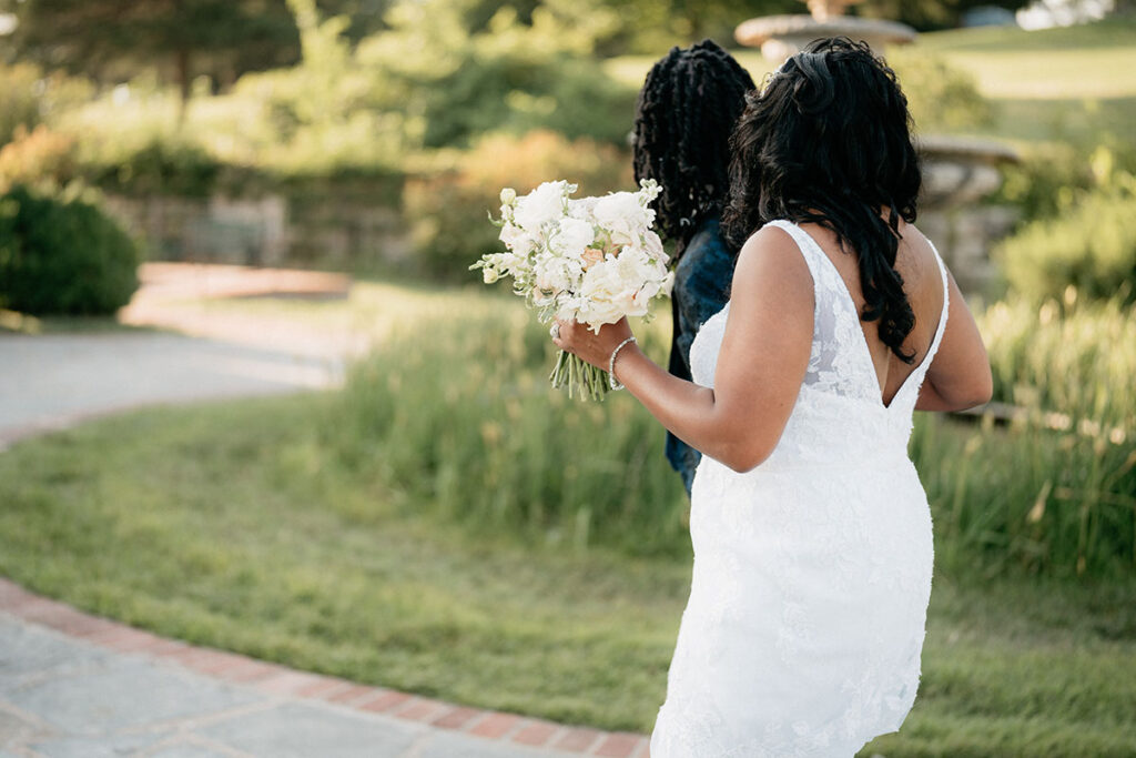 Bride and groom walking together, holding her bouquet
