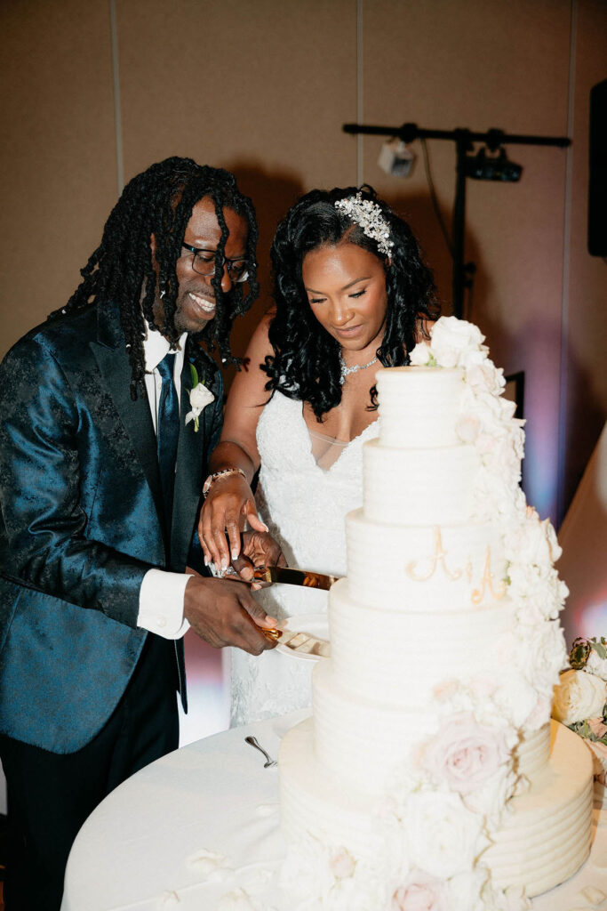 Bride and groom cutting the massive cake with smiles